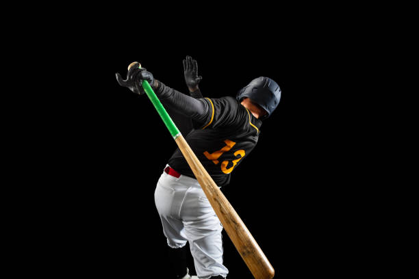 istock Professional baseball player, pitcher in sports uniform and equipment playing baseball isolated on black studio background in neon light. Rear view 1327093374