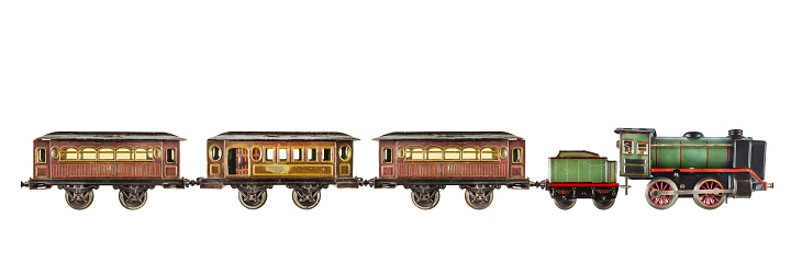 Vintage rusted and weathered toy passenger train with locomotive isolated on a white background