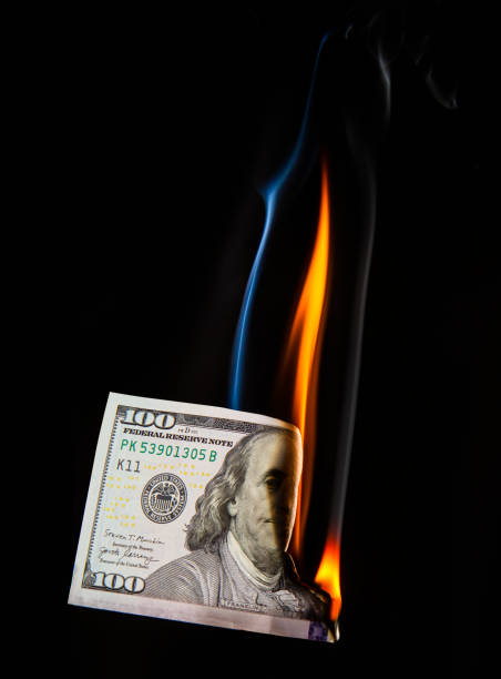 istock conceptual image of half a hundred dollar bill burning with a bright flame on a black background 1327094538