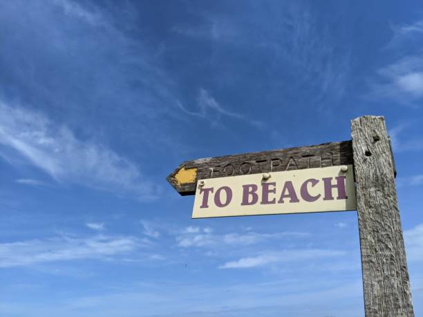 istock To the beach sign surrounded by blue sky 1327094543