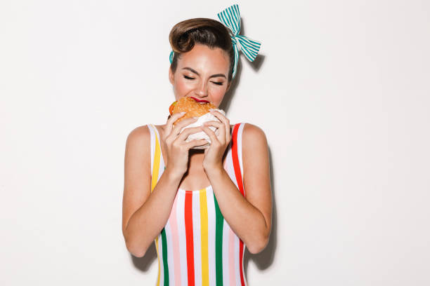 Pretty pin up woman eating burger. stock photo