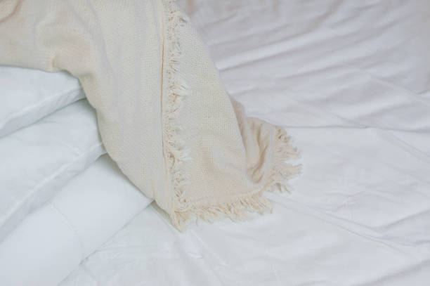 istock stack of white pillows and blankets lies on the bed on a white sheet on top, covered with a blanket 1327099217
