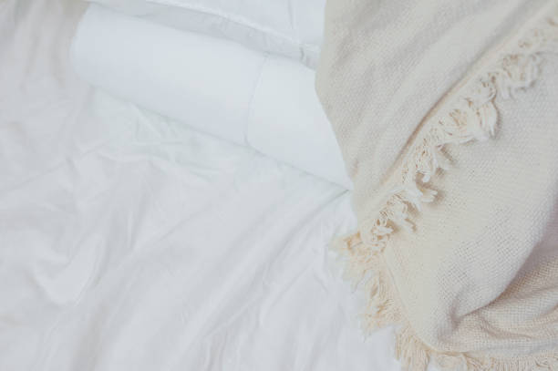 istock stack of white pillows and blankets lies on the bed on a white sheet on top, covered with a blanket 1327099289