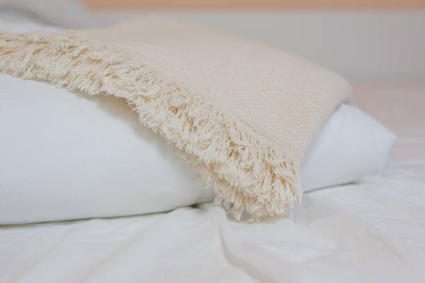 istock stack of white pillows and blankets lies on the bed on a white sheet on top, covered with a blanket 1327099962