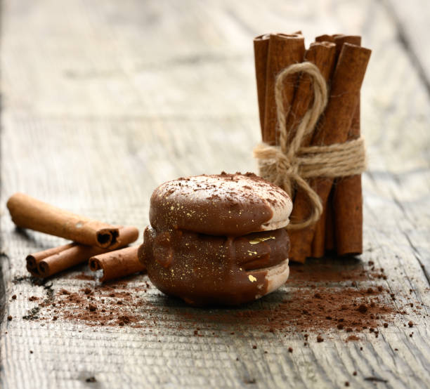 istock baked chocolate macarons and stack of tied cinnamon sticks on gray background 1327100400
