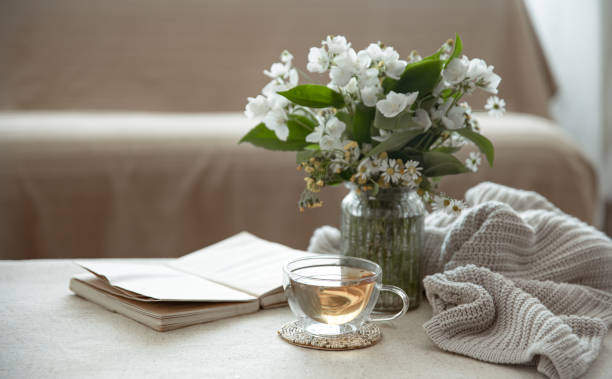 istock Cozy home composition with a cup of tea, a book and flowers copy space. 1327101705