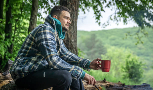 istock A man on a hike sits by the fire and warms himself. 1327103179
