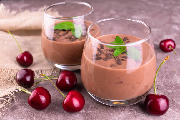istock Two glasses with chocolate cherry smoothies on a gray background. 1327103628