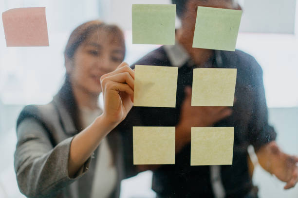 istock Businesswoman writing on sticky notes in office 1327104728