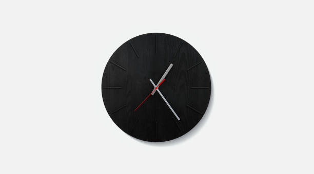Stylish black round clock on a white wall. Time on the wall as an element of the interior. Simple modern round clock on white wall