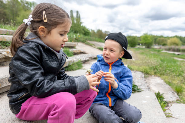 istock Little girl and boy communicate while sitting in the park. 1327104907