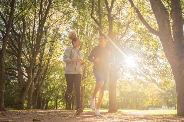 istock Young couple running in the public park 1327105516