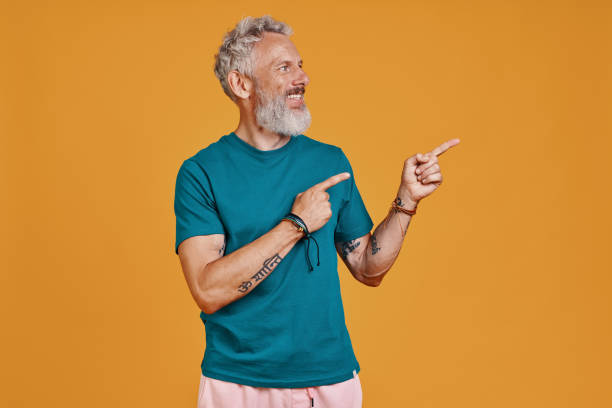 istock Happy senior man pointing copy space and smiling 1327106399