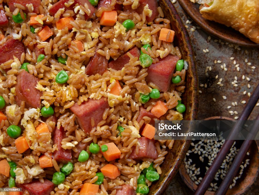 Fried Rice with Fried Spiced Ham Fried Rice with Fried Canned Spiced Ham, Vegetables and an Eggroll Fried Rice Stock Photo