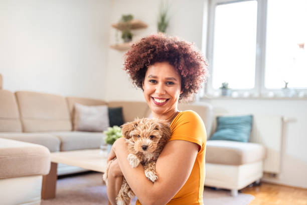 istock Young woman holding puppy on her lap 1327108389