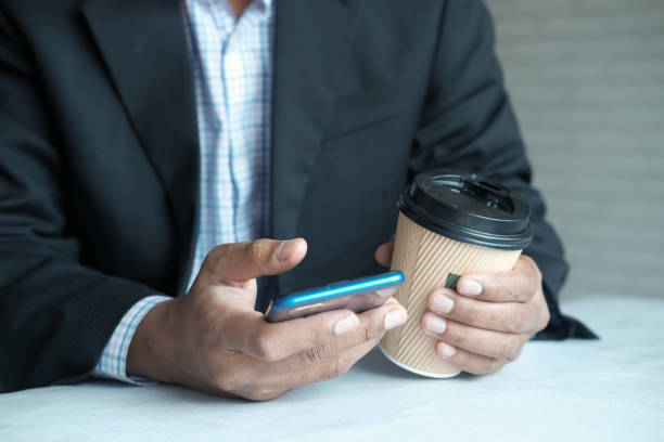 istock businessman hand using smart phone and paper coffee cup 1327110039