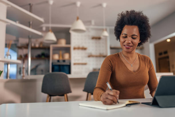 istock Adult woman, writing down her thoughts, at home office. 1327112062