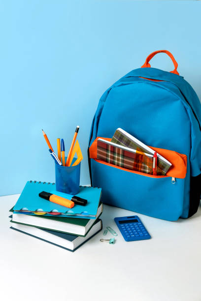 istock School backpack with colorful school supplies on blue background. Banner design 1327112092