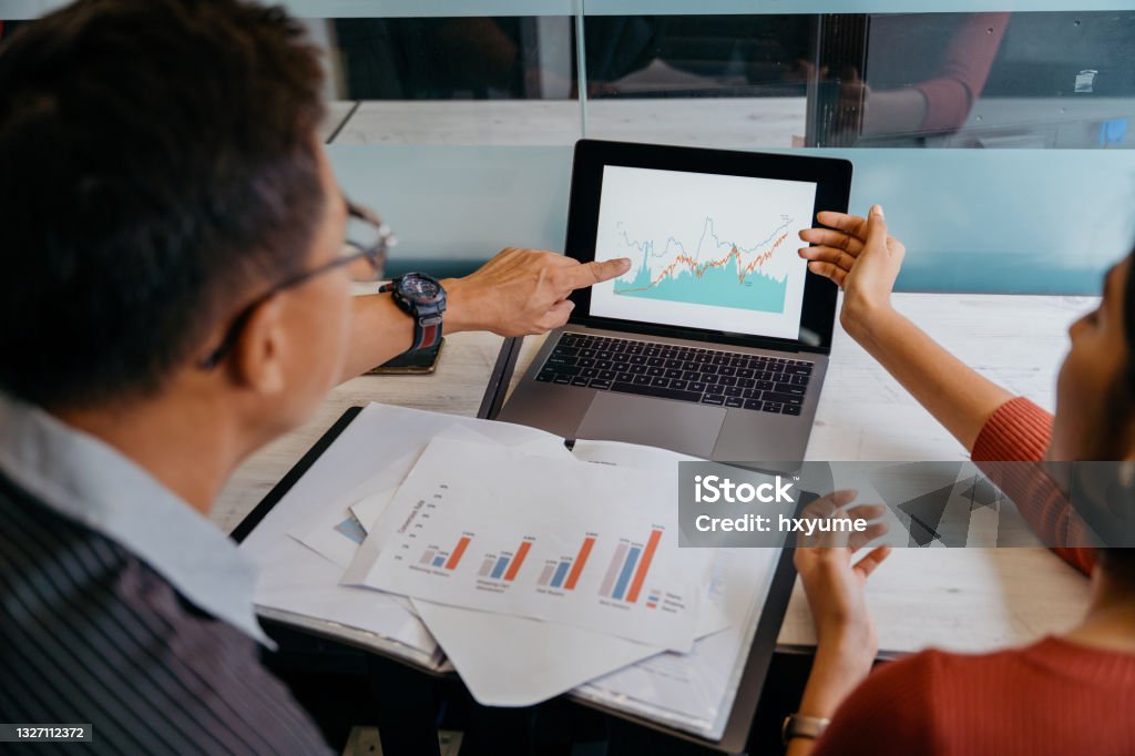 Asian business professionals working in office Image of a team of asian business people doing market research and business plans in office Data Stock Photo