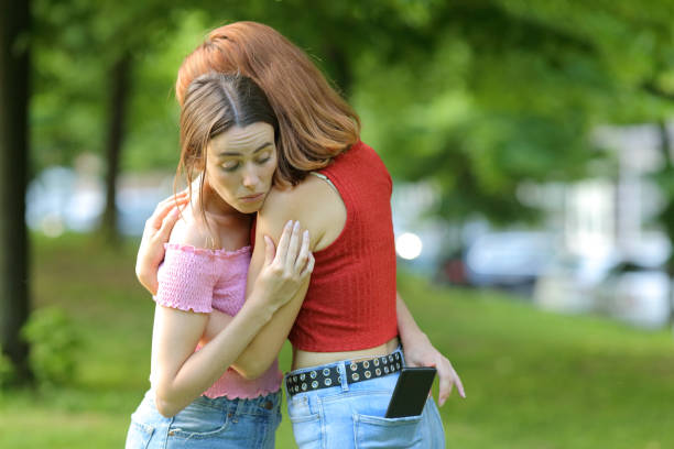 istock Woman spying her friend checking phone content 1327112387