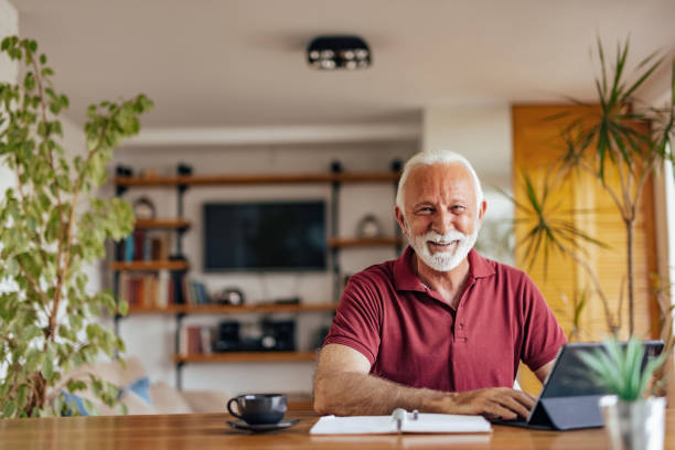 istock Senior man, taking a picture in his home office. 1327112488