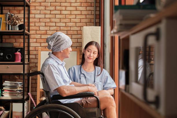Cancer patients in wheelchairs receive rehabilitation treatment in private home. stock photo