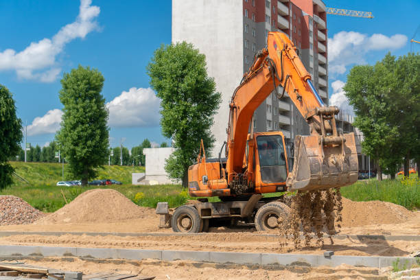 istock Wheeled backhoe loader with a bucket pours sand into the space for the future sidewalk. Construction of a pedestrian street. Work on laying paving slabs. Heavy machinery 1327114986
