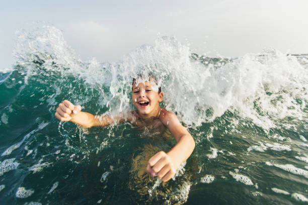 istock Happy child playing in the sea. 1327115830