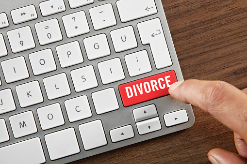 Man pushing “Divorce” key on computer keyboard.