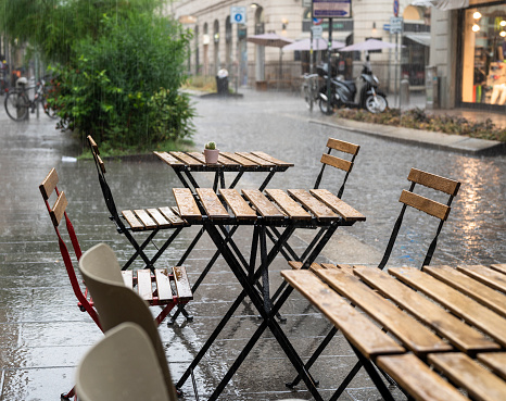 Empty table and chairs outside a cafe on a sidewalk