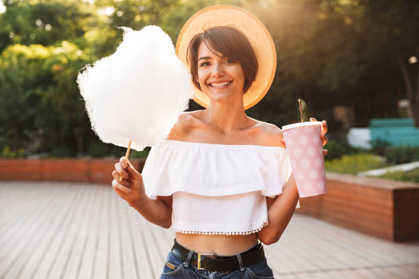 istock Smiling young girl dressed in summer clothes eating 1327119344