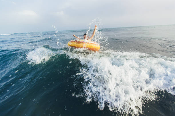 istock Child on inflatable ring ride on breaking wave. 1327119795