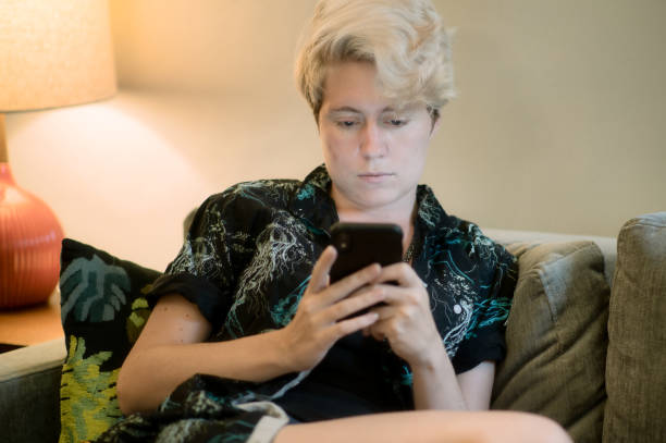 istock Teen looking at phone while resting on sofa 1327119875