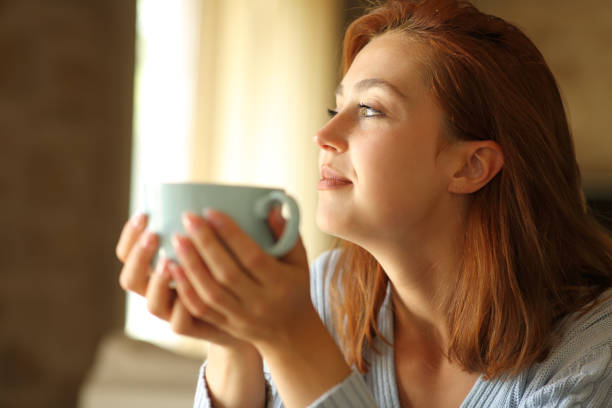 istock Woman contemplating drinking coffee at home 1327122448