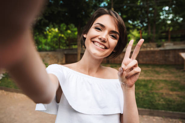 istock Smiling young girl showing peace gesture 1327123825