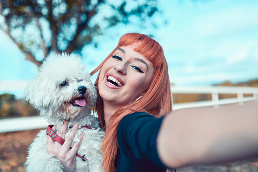 Cute Female Taking Selfie With Pet Poodle Outside