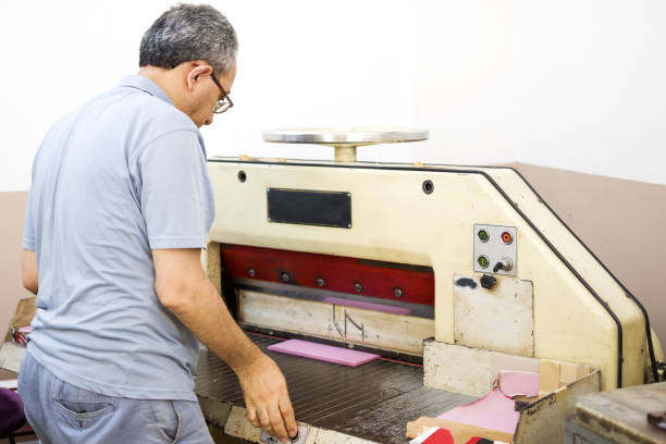 istock Man working with cutting machine at the printing plant 1327126730