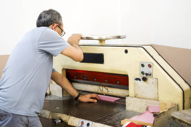 istock Man working with cutting machine at the printing plant 1327126939