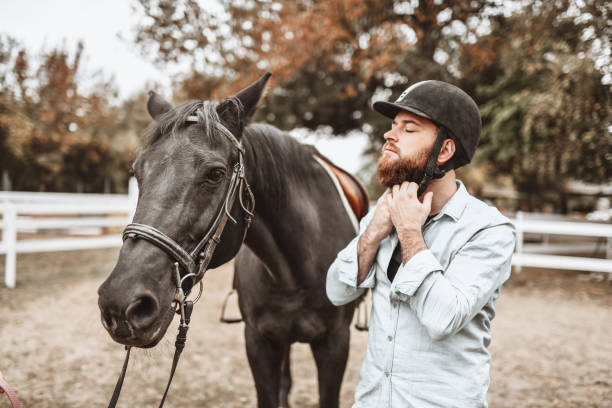 istock Bearded Jockey Strapping On Helmet And Getting Ready For A Ride 1327128822