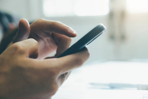 istock Close up of man using mobile phone. 1327128839