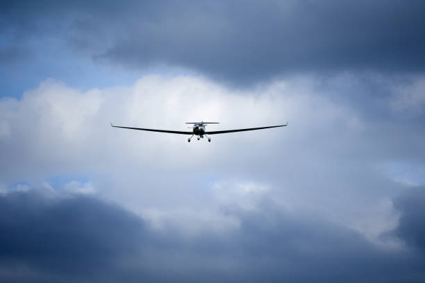 istock Small aircraft on landing approach. Dramatic sky with blue gray clouds. Front view. 1327128994