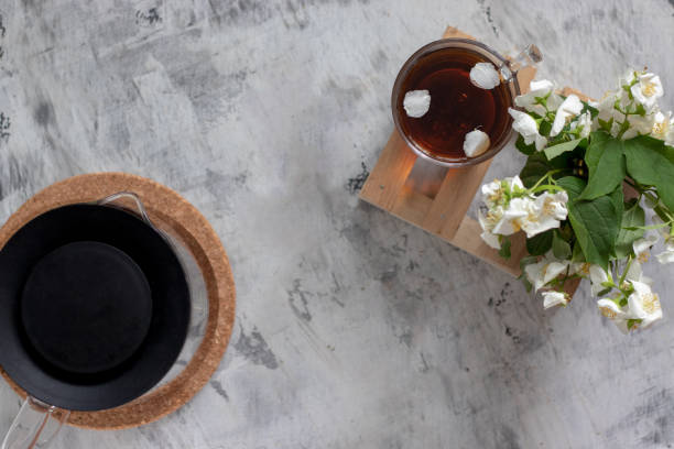 vista dall'alto. una teiera con coperchio nero e una tazza di teiera su un tavolo bianco - tea jasmine tea green black foto e immagini stock