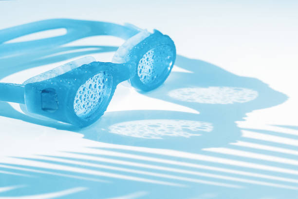 blue swimming goggles on a blue background with copy space
