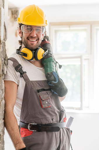 Worker using hammer drill, home renovation