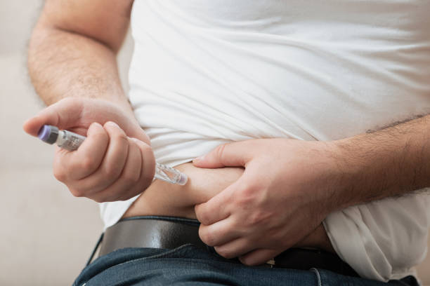 istock Man is injecting insulin into his stomach 1327134509