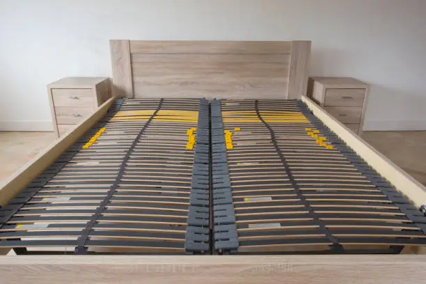 Photo of Slatted base, wooden element double bed frame close up in bedroom orthopedic