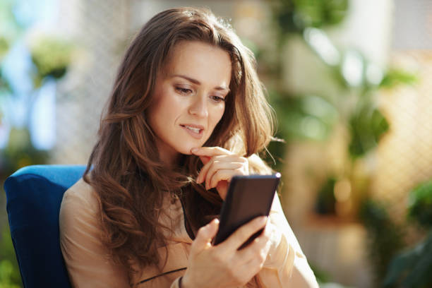 istock stylish woman in sunny day sending text message using phone 1327138069