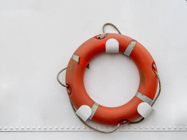 real laranja cor lifebuoy pendurado no fundo do barco branco. - life jacket life belt buoy float - fotografias e filmes do acervo