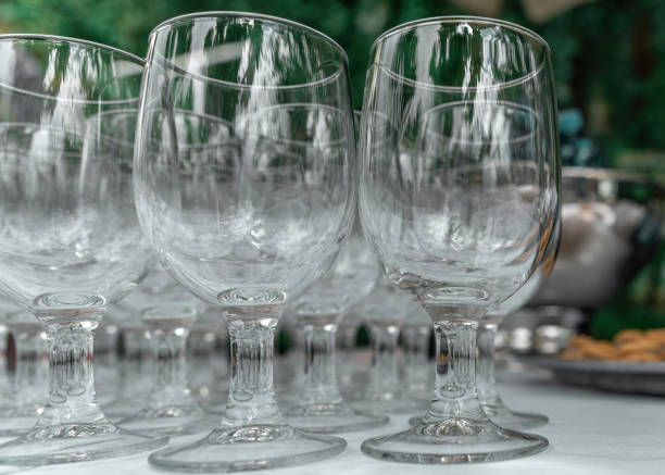 istock Empty glass transparent wine glasses on a table on a blurry background. Wine glasses in row. Selective focus, close up 1327143488