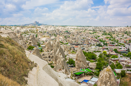 Goreme, Turkey - panorama view of the town of Goreme in Cappadocia, Turkey with fairy chimneys, houses, and unique rock formations seen from sunrise point